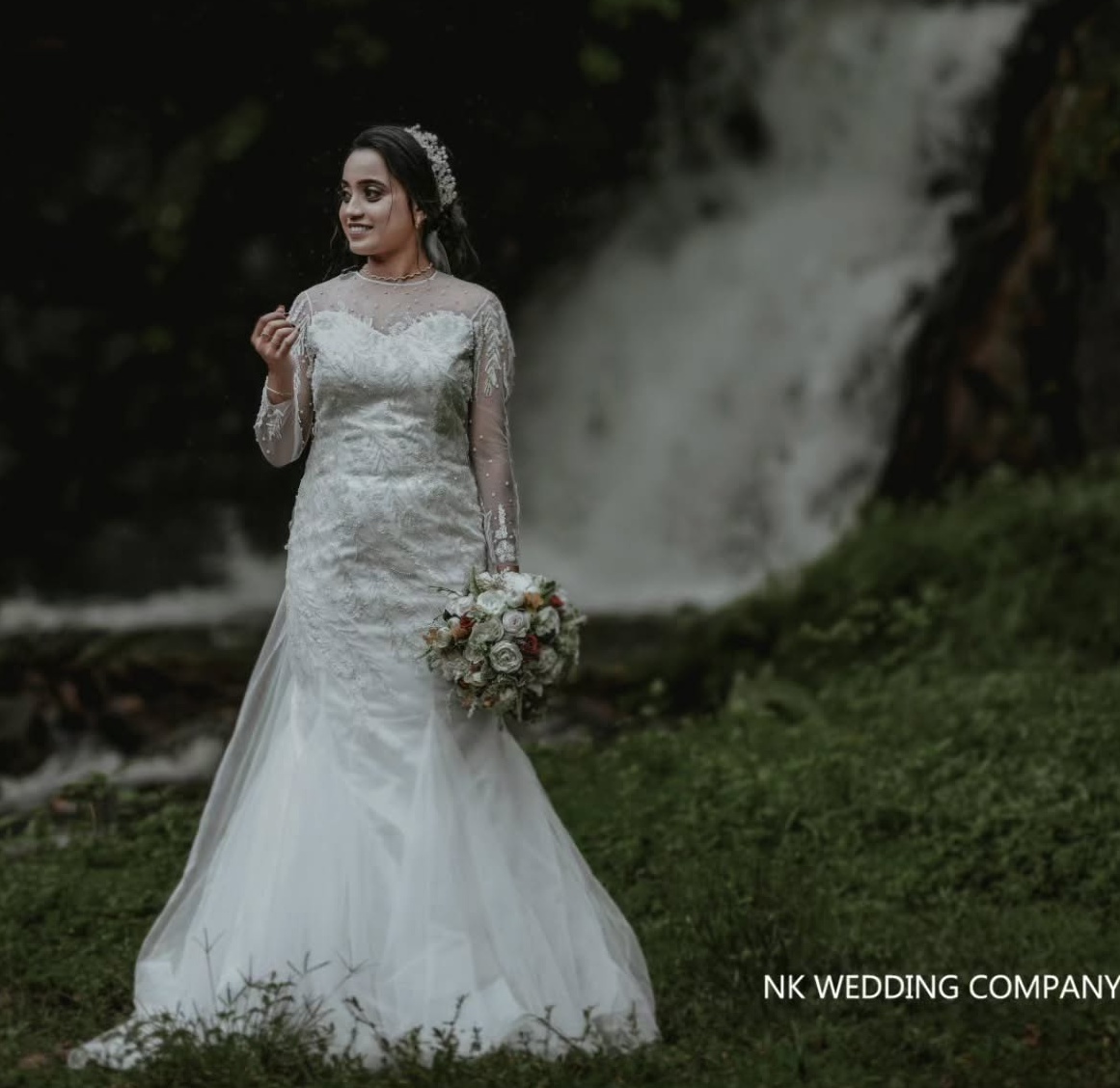 Bride holding her bouquet beside a waterfall