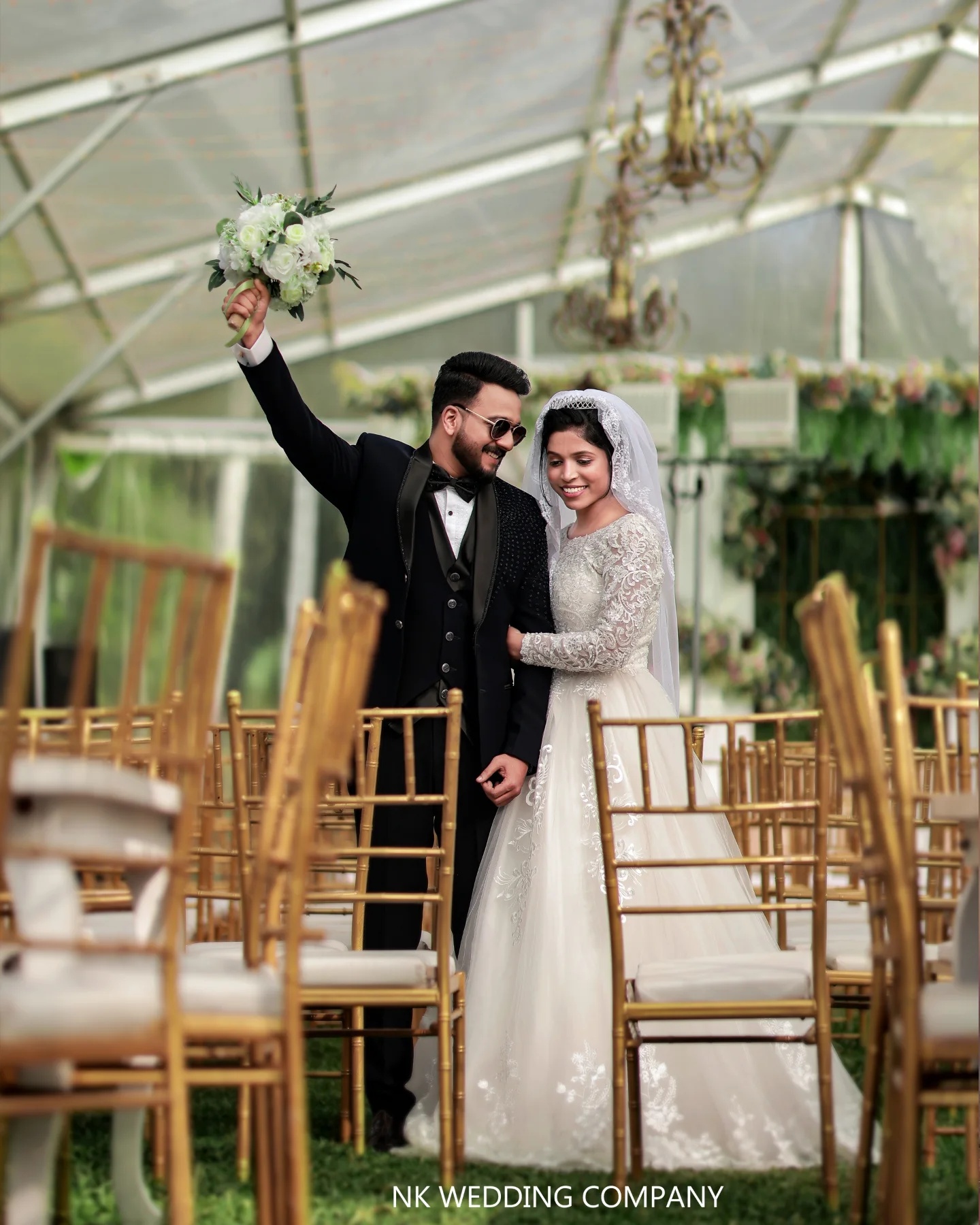 Newlyweds celebrating between reception chairs