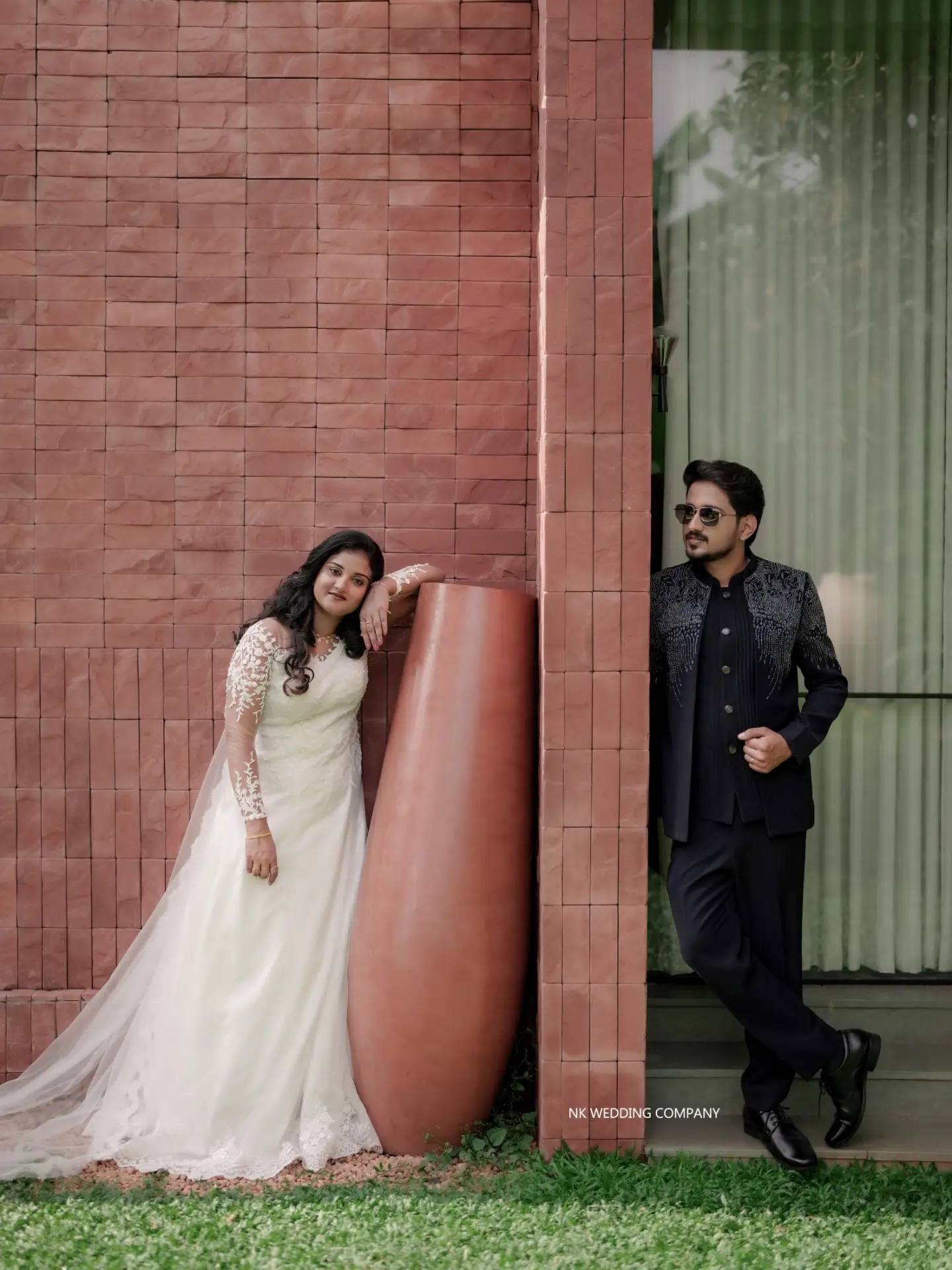 Wedding couple posed against modern architecture